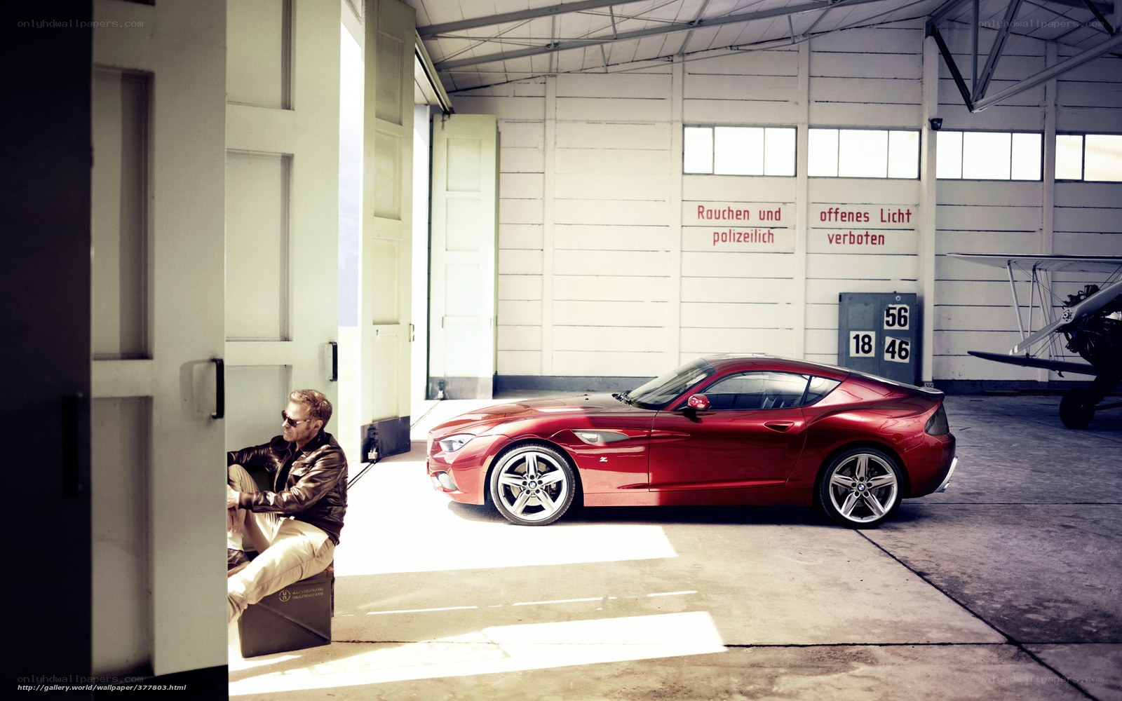 Man with red car in hangar