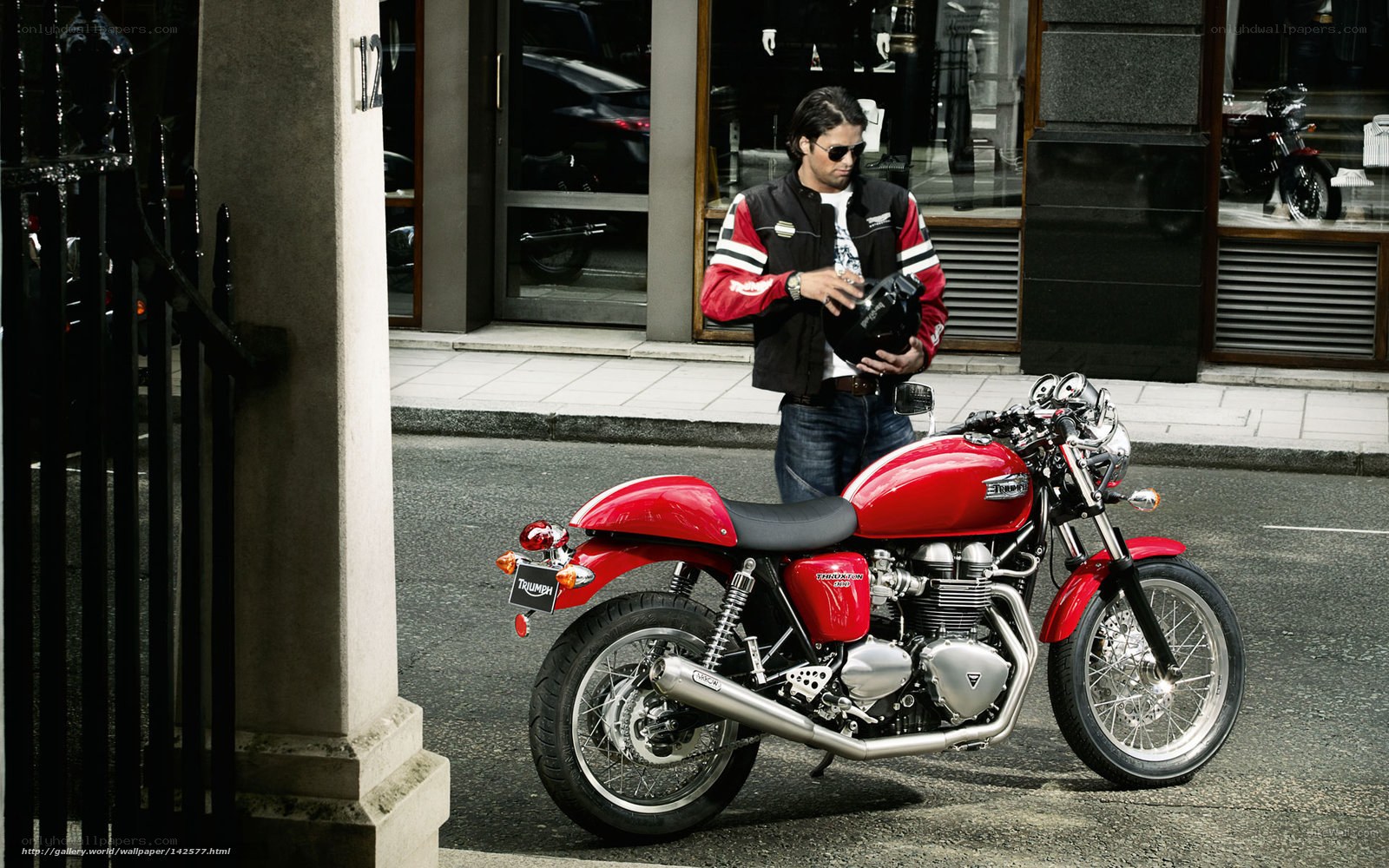 Man with red motorcycle on street