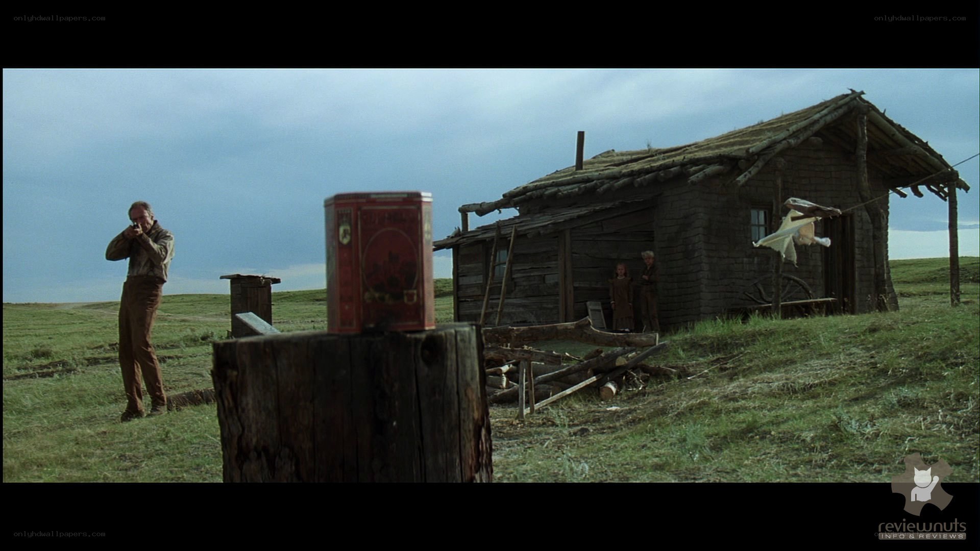 Man with rifle near cabin