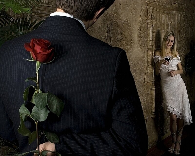Man with rose behind back