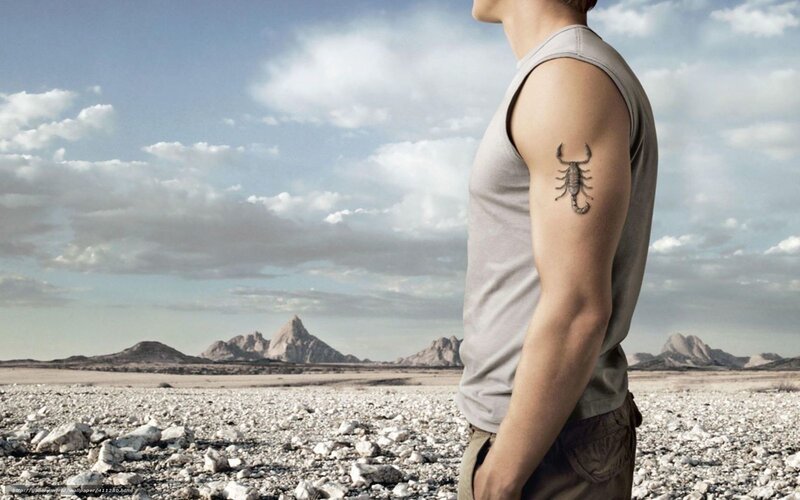 man with scorpion tattoo in desert