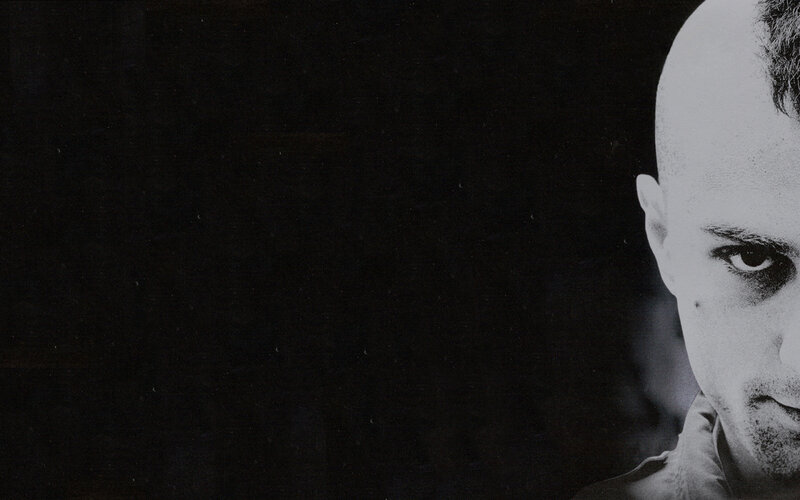 man with shaved head in black and white