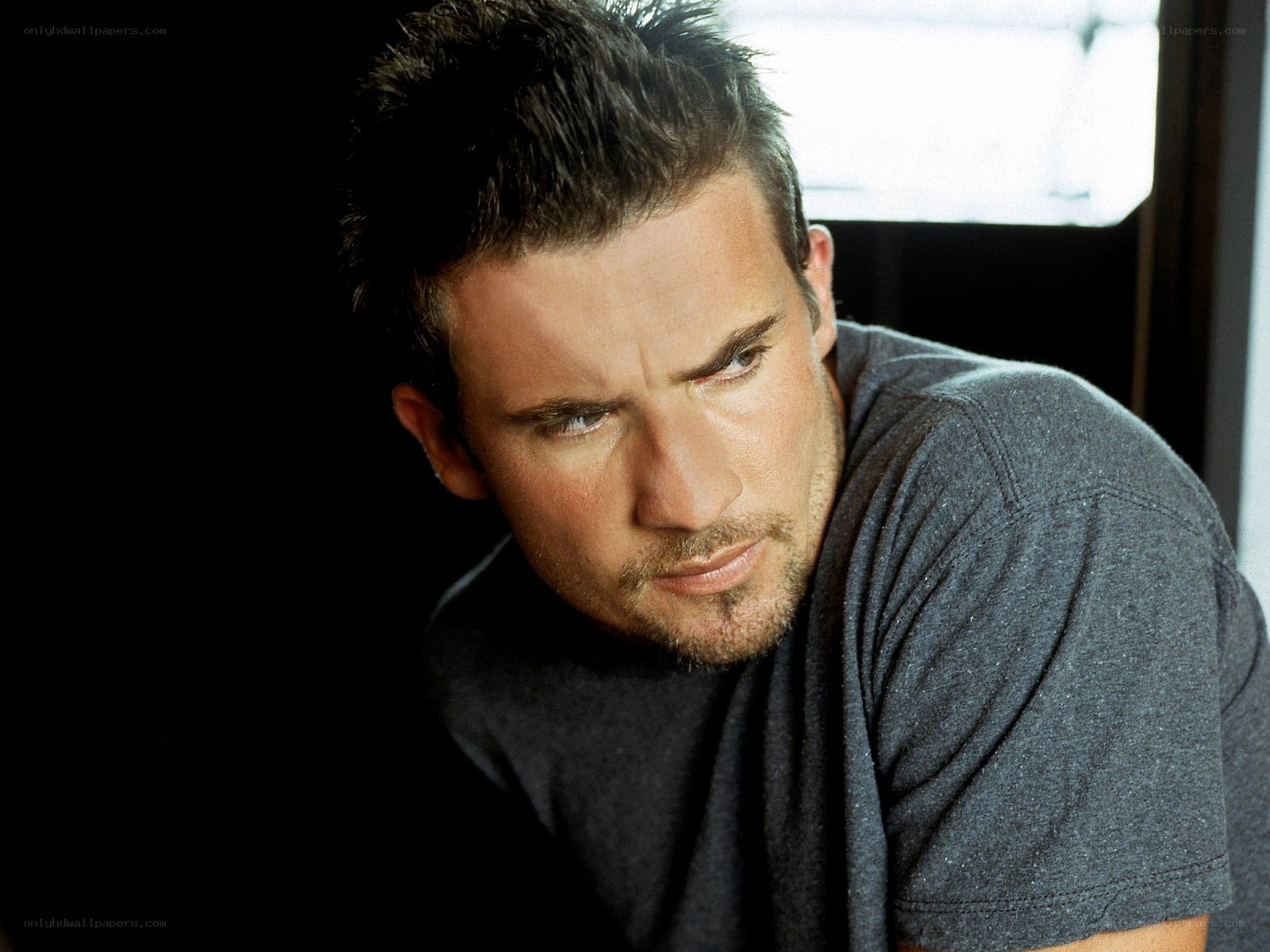 man with short hair looking down
