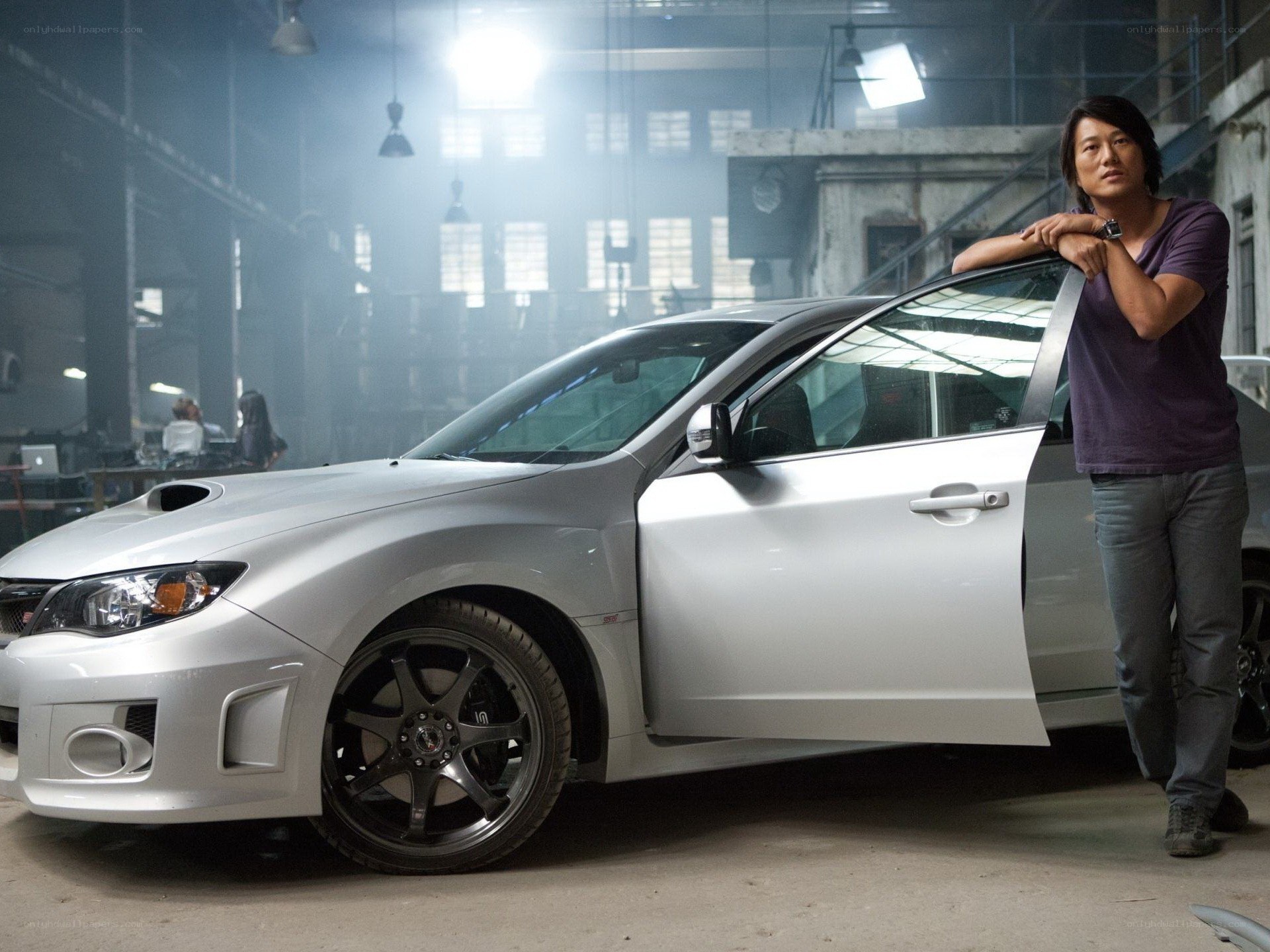 man with silver car in warehouse