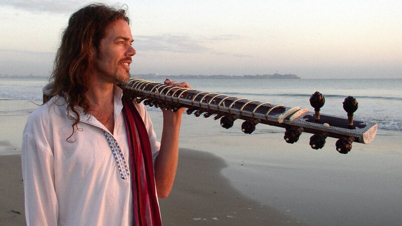 Man with sitar on beach