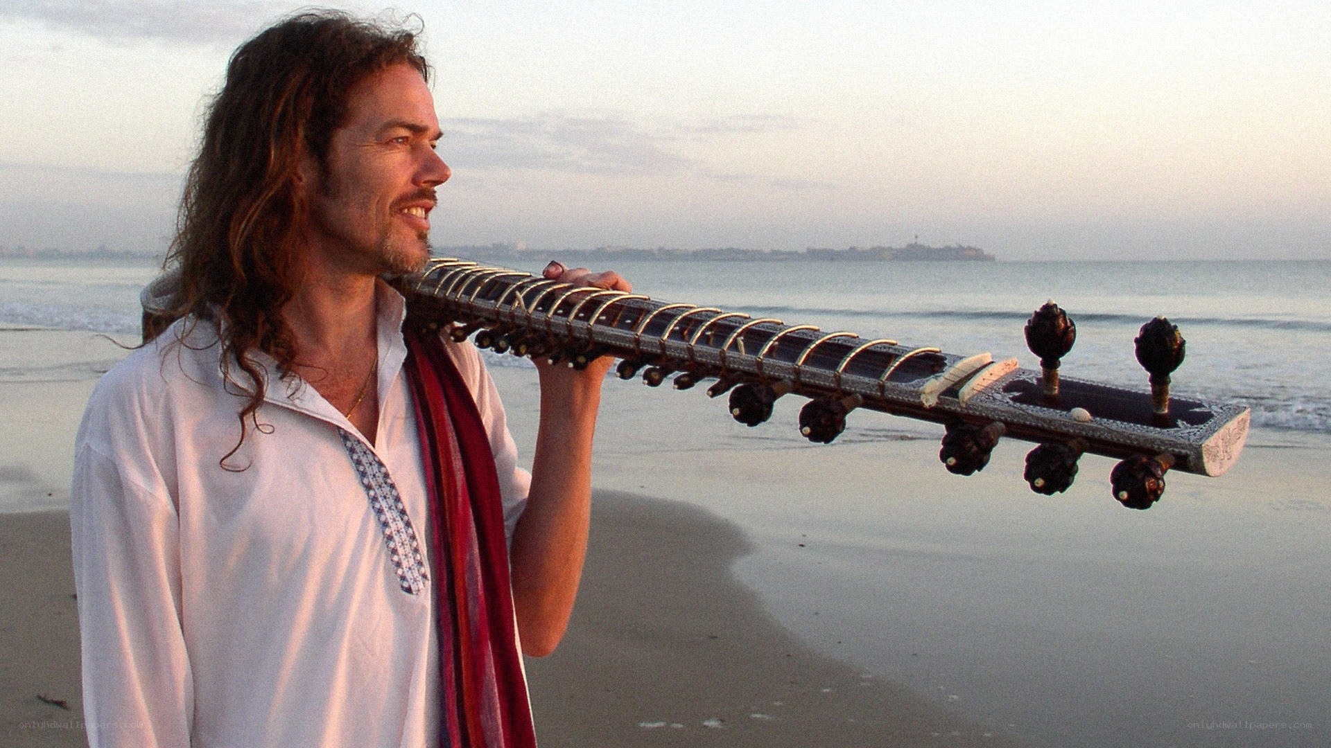 Man with sitar on beach