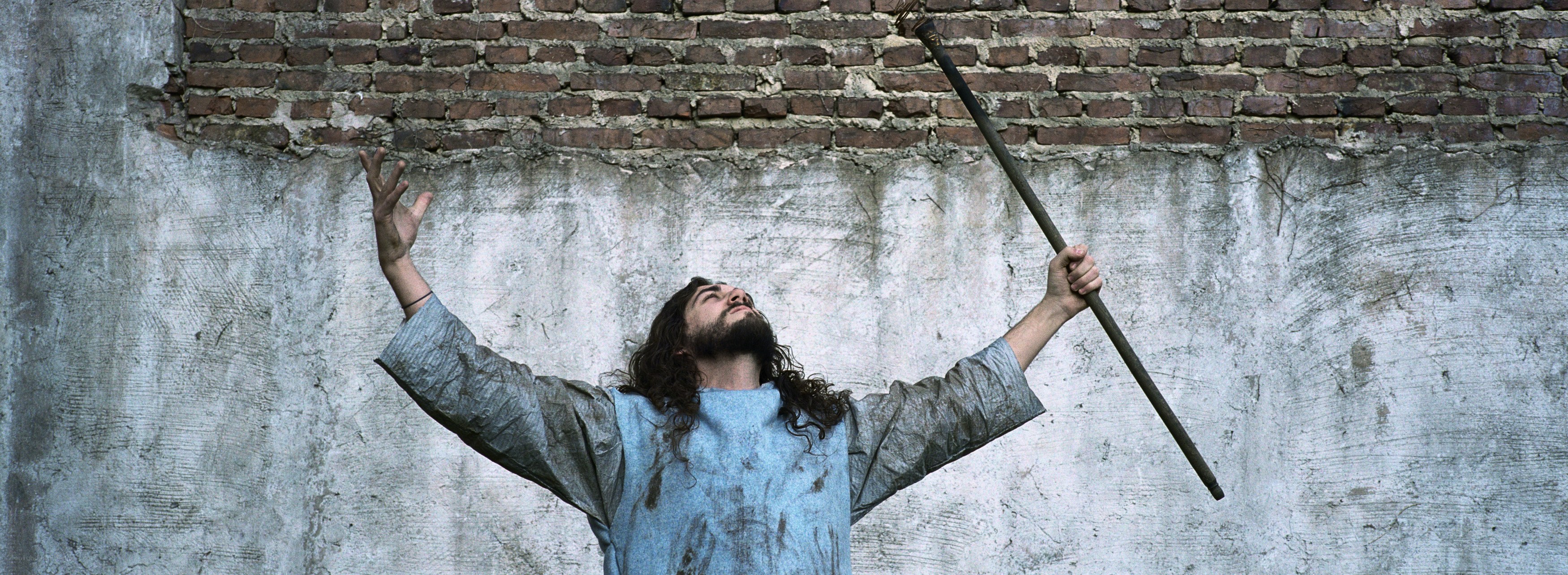 man with staff and raised arms