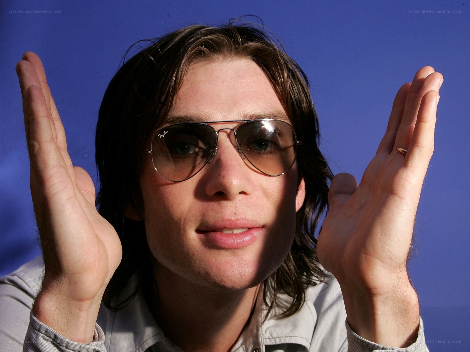 man with sunglasses and raised hands