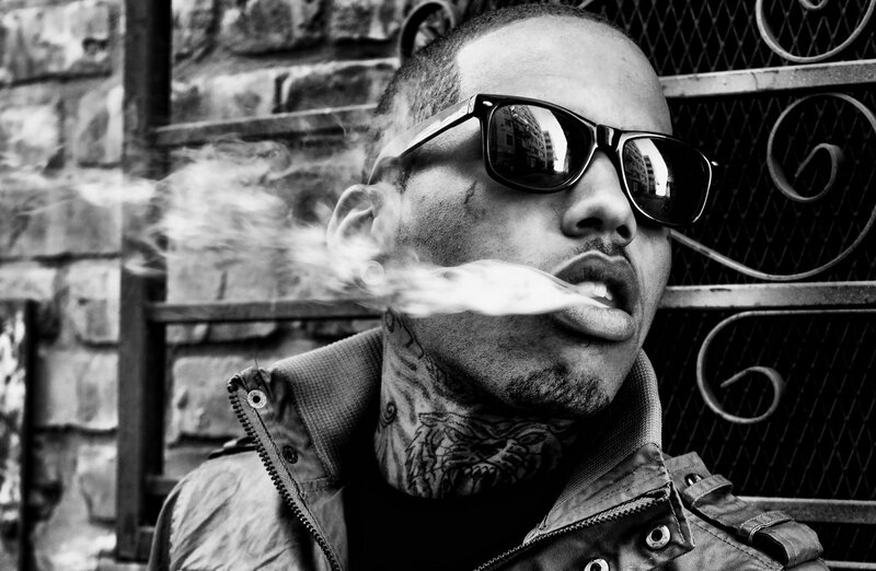 man with sunglasses exhaling smoke