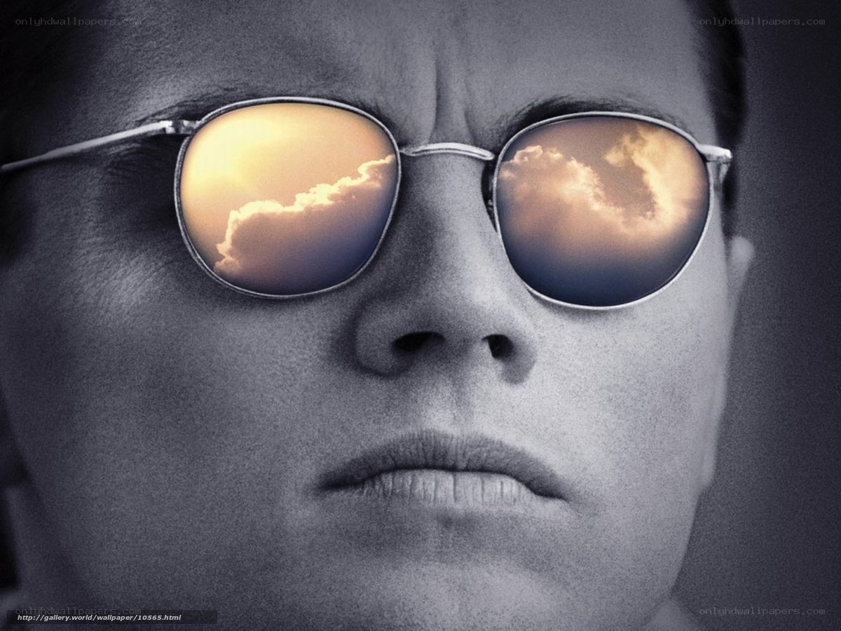Man with sunglasses reflecting sky