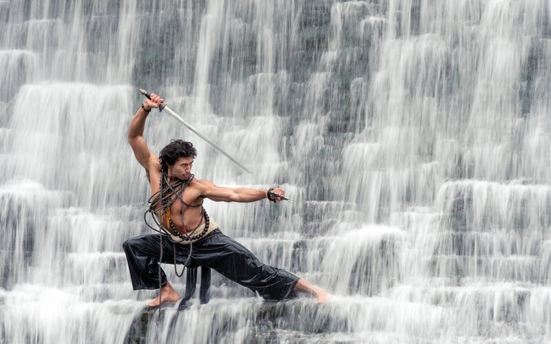Man with sword at waterfall