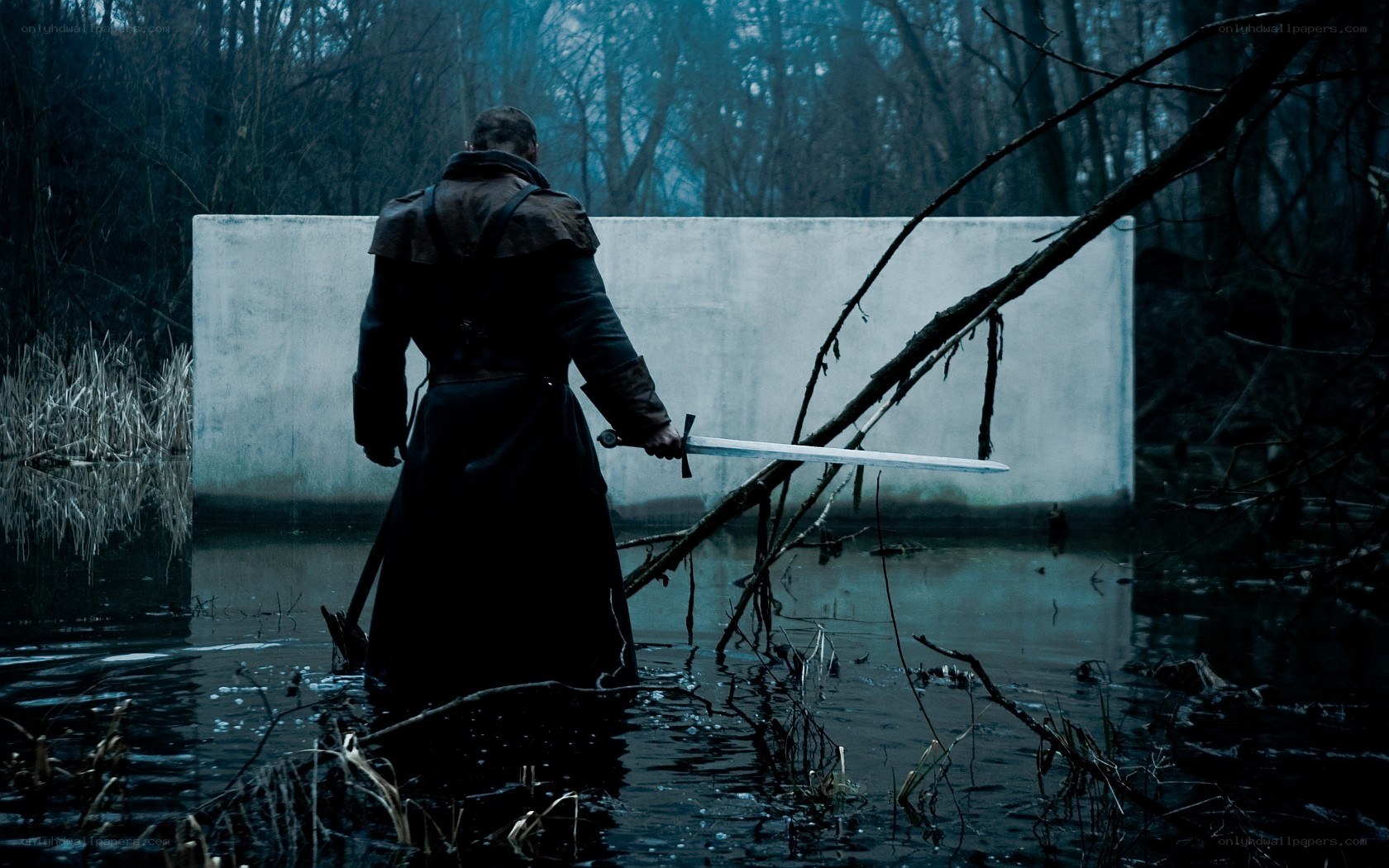man with sword in swamp