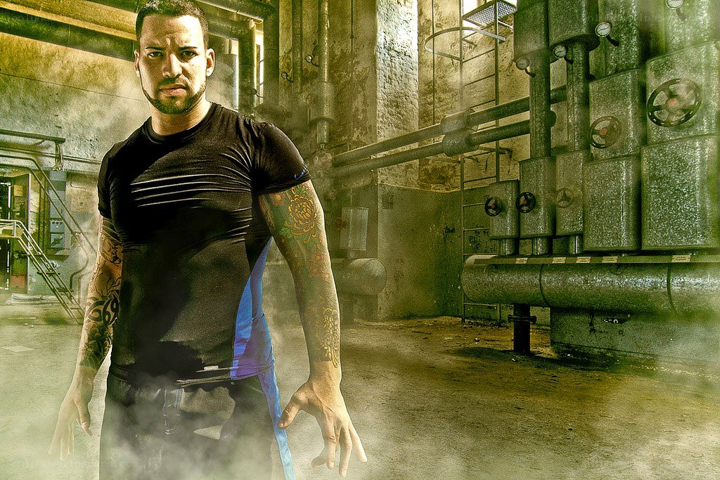 man with tattoos in industrial setting