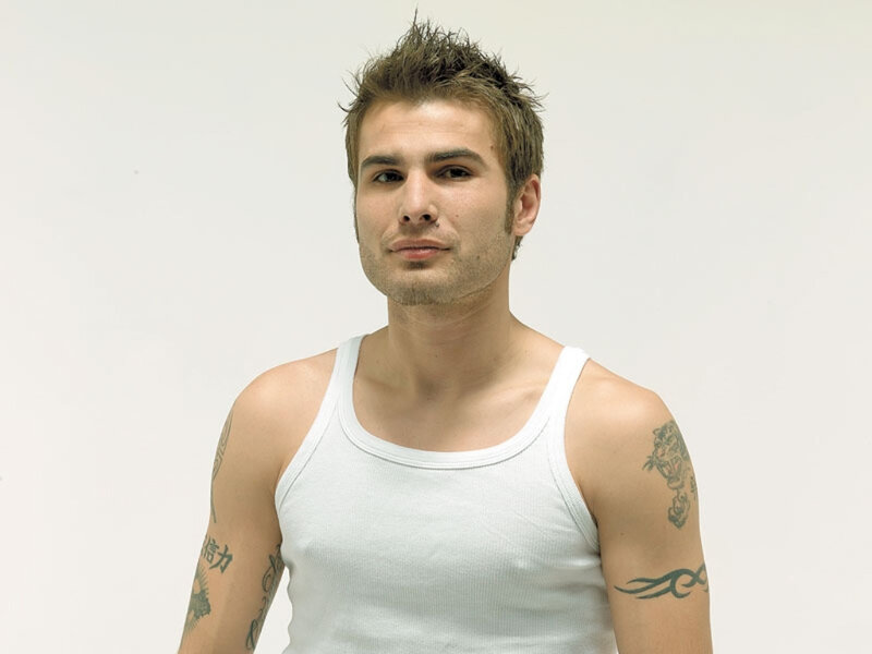 man with tattoos in white tank top