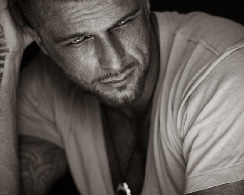 man with tattoos looking down