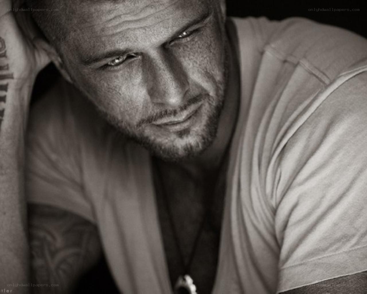 man with tattoos looking down