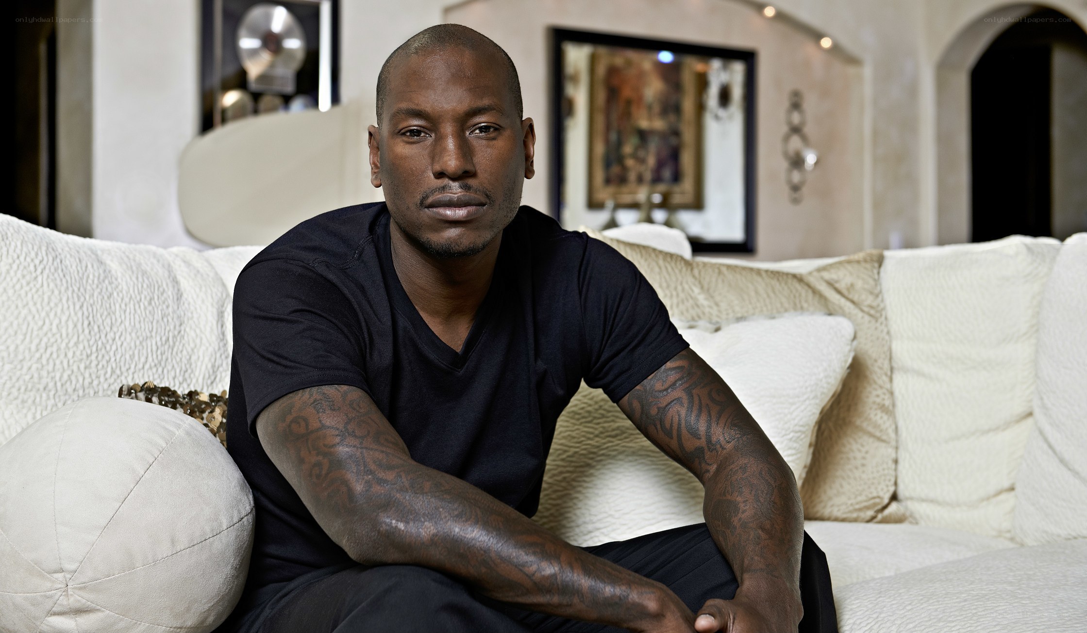 man with tattoos on couch