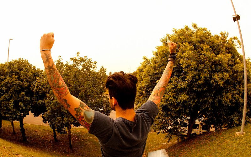 man with tattoos raising fists