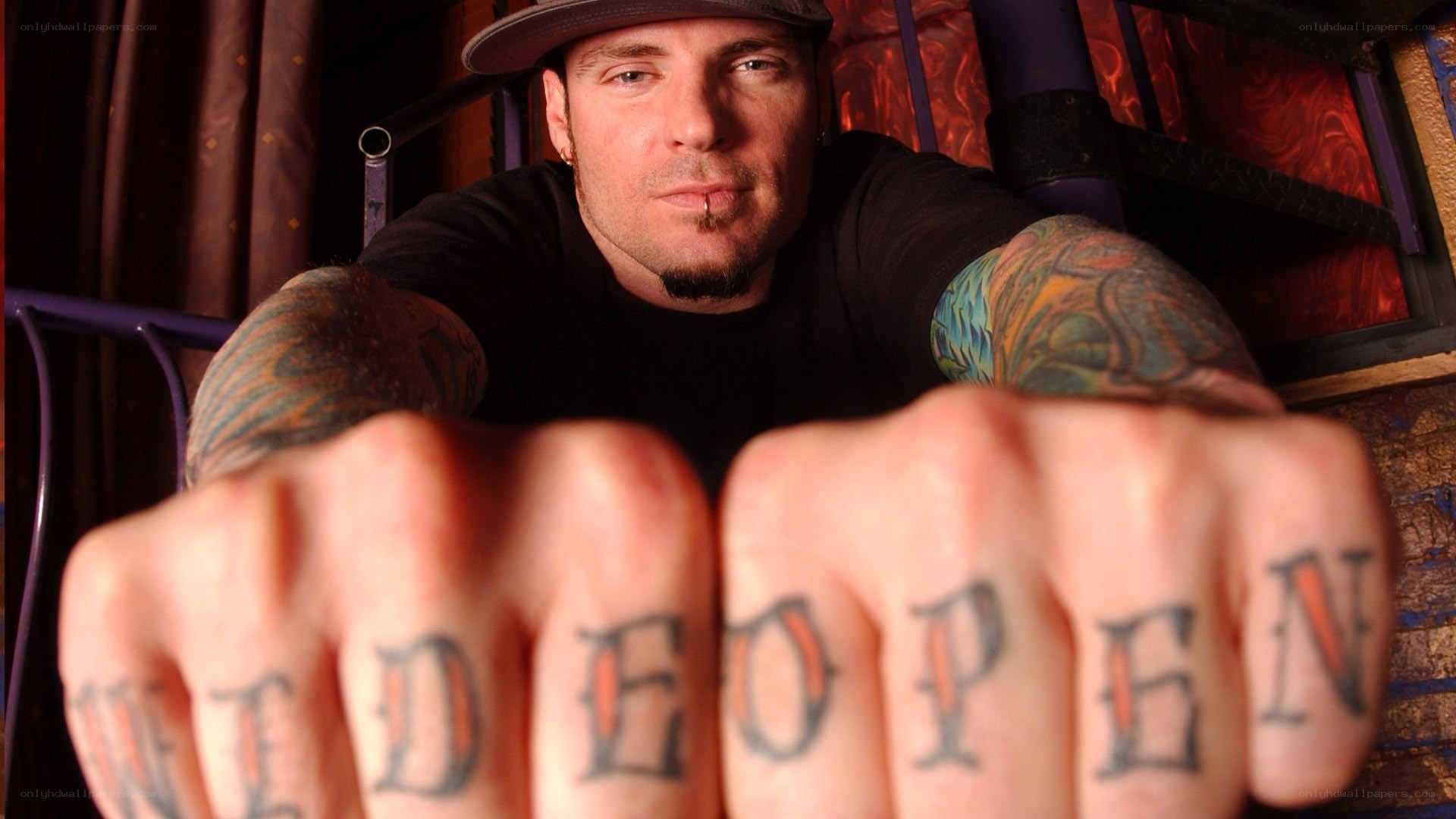 Man with tattoos showing 'WIDE OPEN'