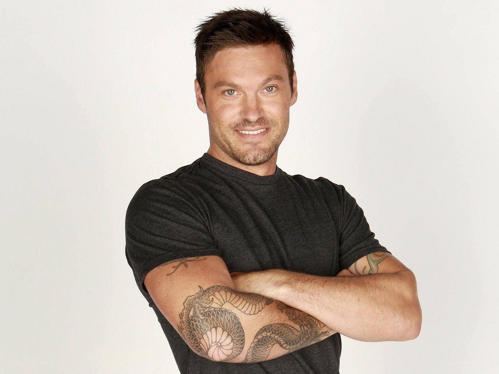 man with tattoos smiling