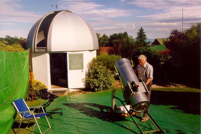 Man with telescope near observatory