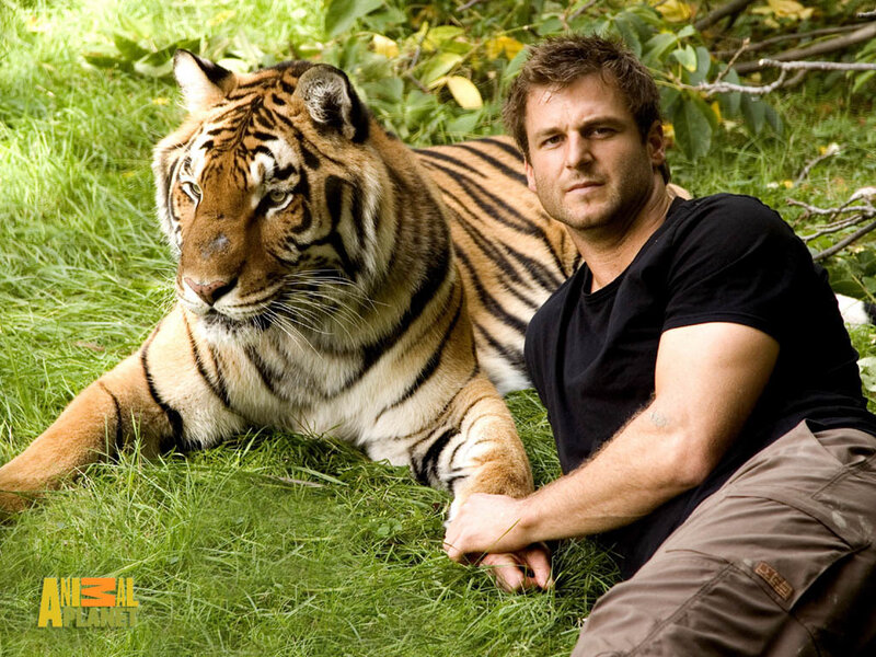 Man with tiger in grass