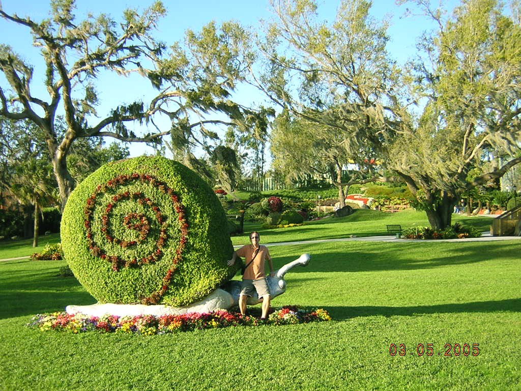 Man with topiary snail sculpture
