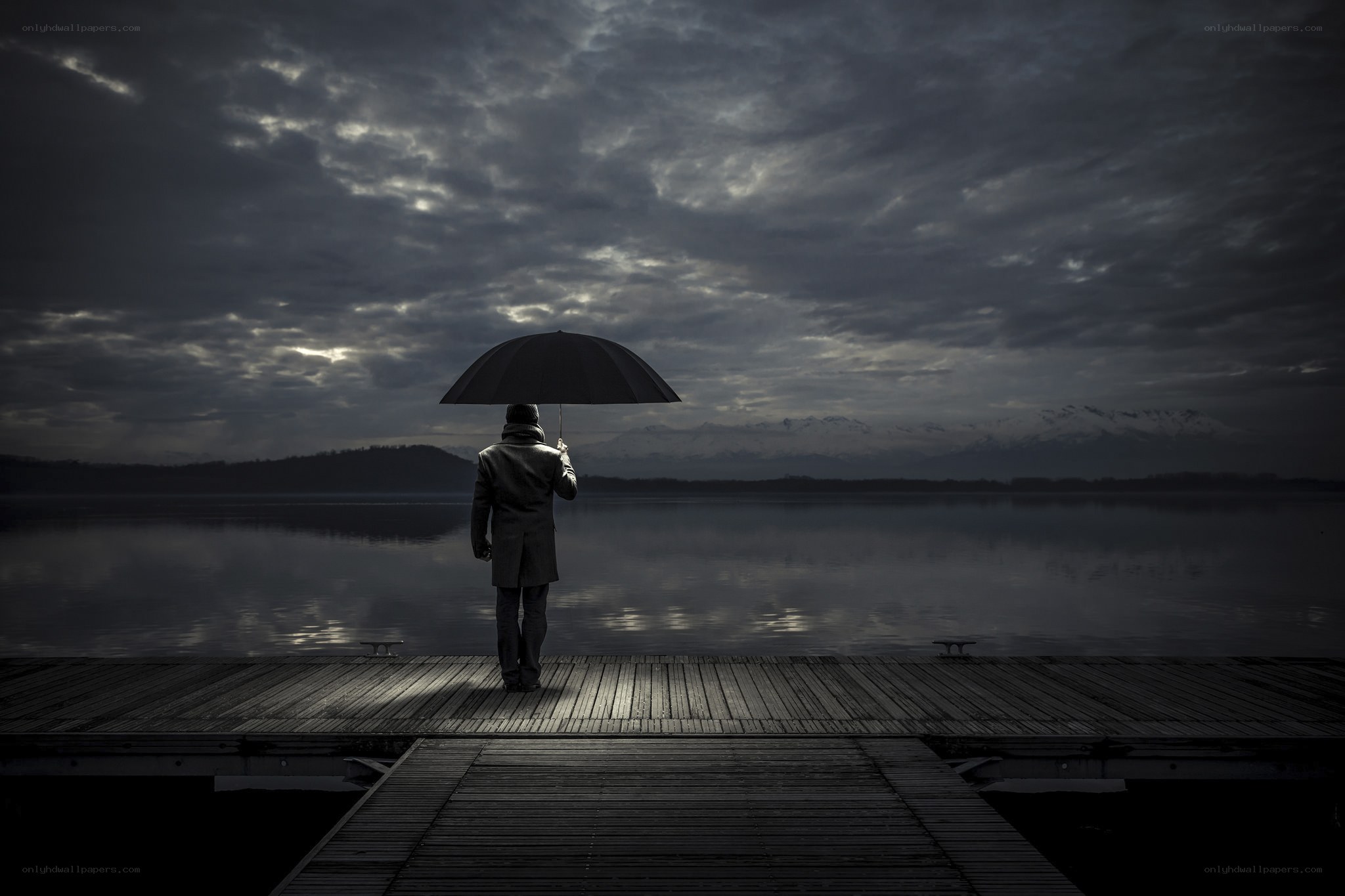 Man with umbrella on dock