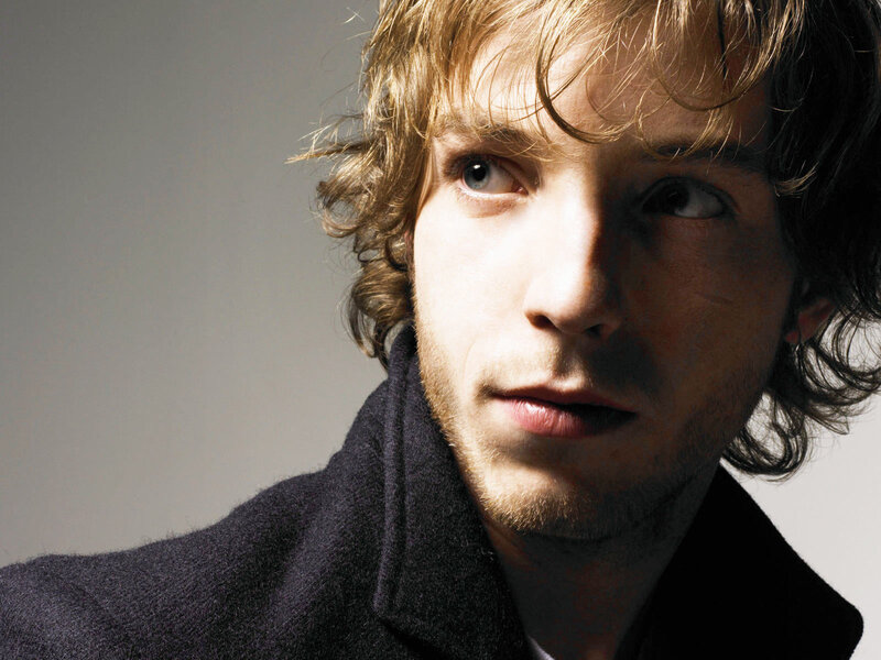 man with wavy hair in coat