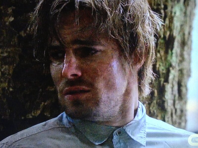 man with wet hair against tree