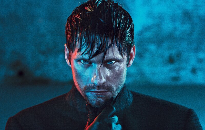 man with wet hair in blue light