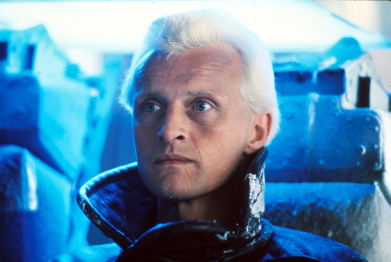 man with white hair in blue light