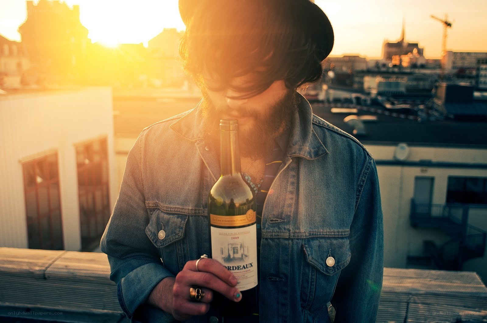 man with wine bottle on rooftop