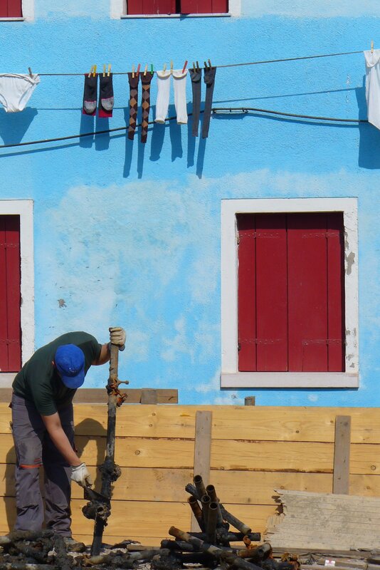 Man working in front of blue building