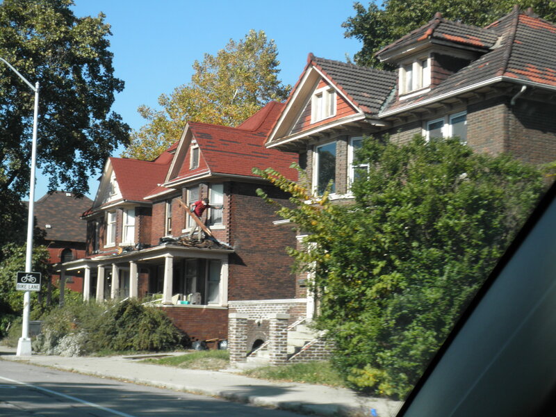 Man working on roof of brick house