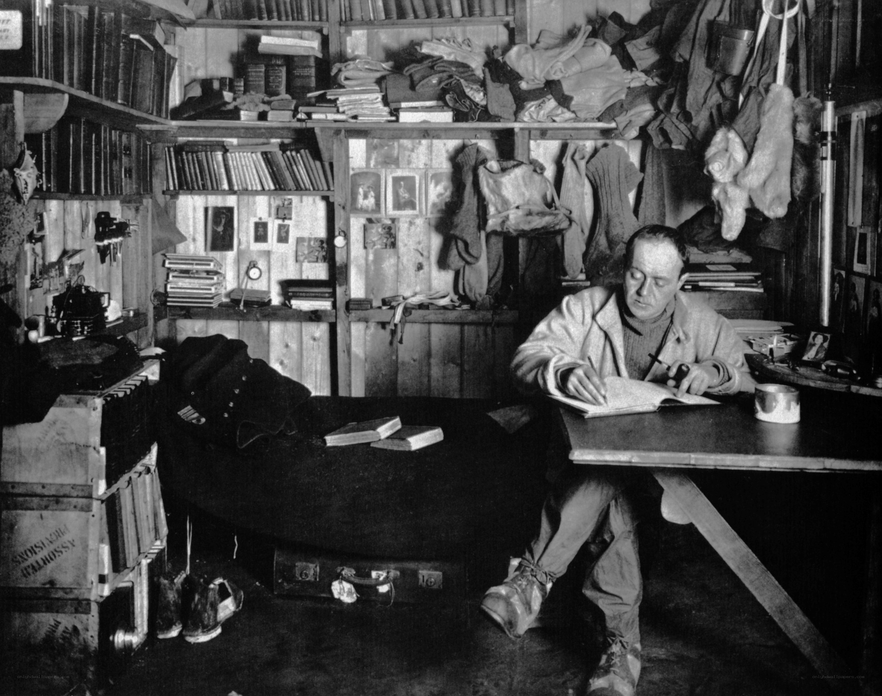 Man writing in a cluttered cabin