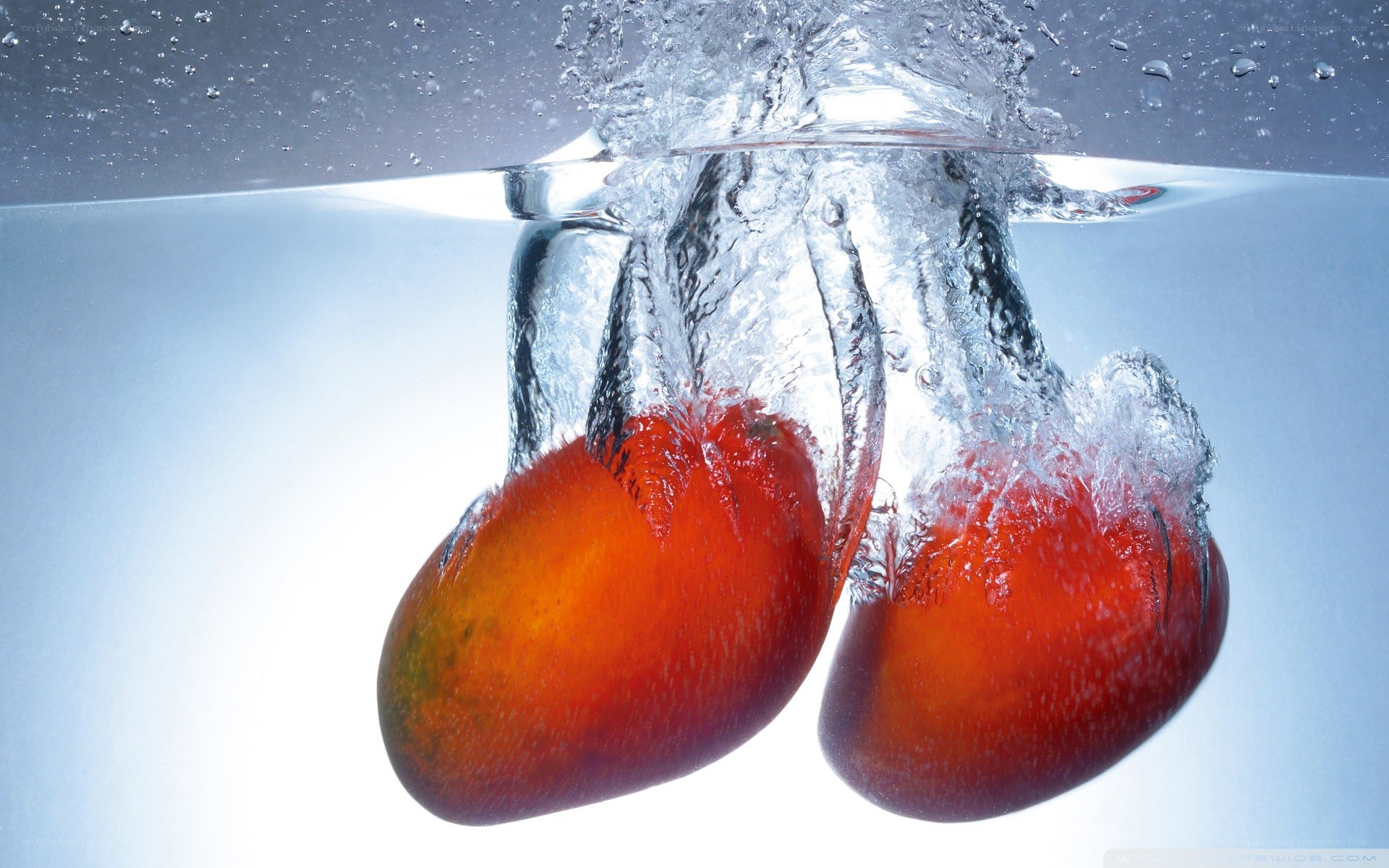 mangoes splashing in water