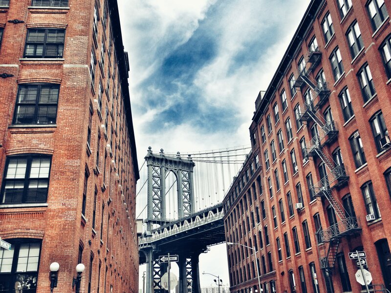 Manhattan Bridge between brick buildings