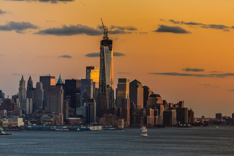 Manhattan Skyline at Sunset — Orange, Dramatic, Photograph, Skyscrapers, River, Boats, Clouds