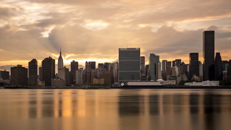 Manhattan Skyline at Sunset — Orange, Dramatic, Photograph, Skyscrapers, River, Clouds