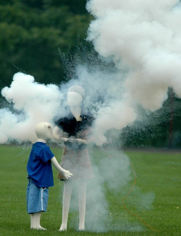 Mannequins in smoke on grass