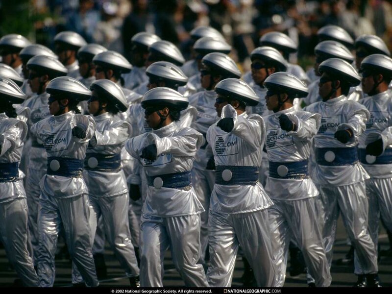 Marching performers in silver uniforms