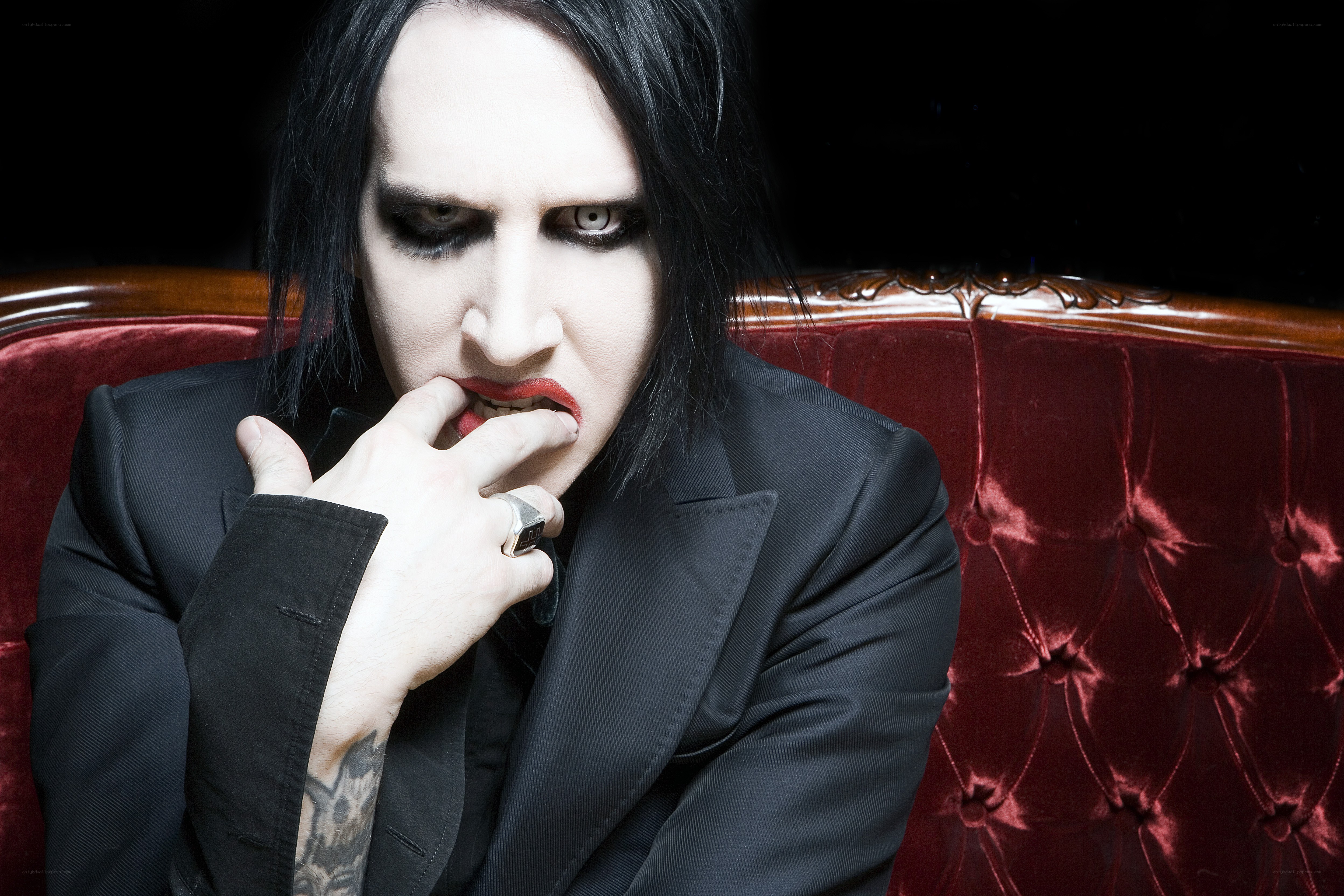 Marilyn Manson on red couch