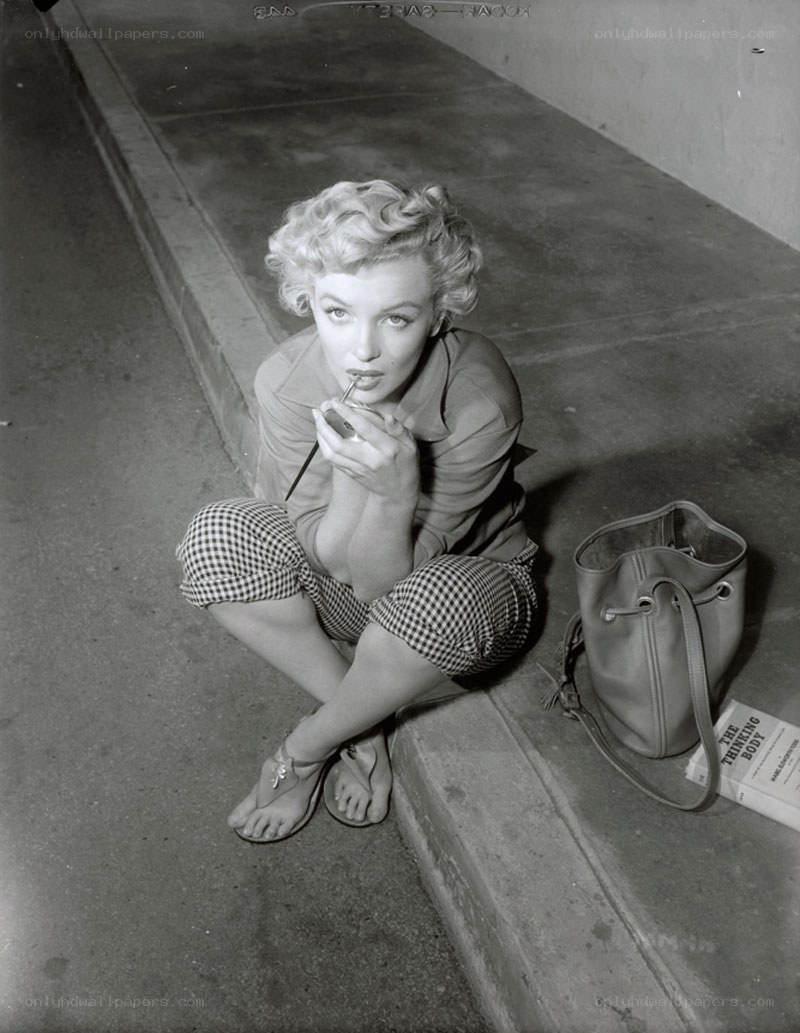 Marilyn Monroe applying lipstick