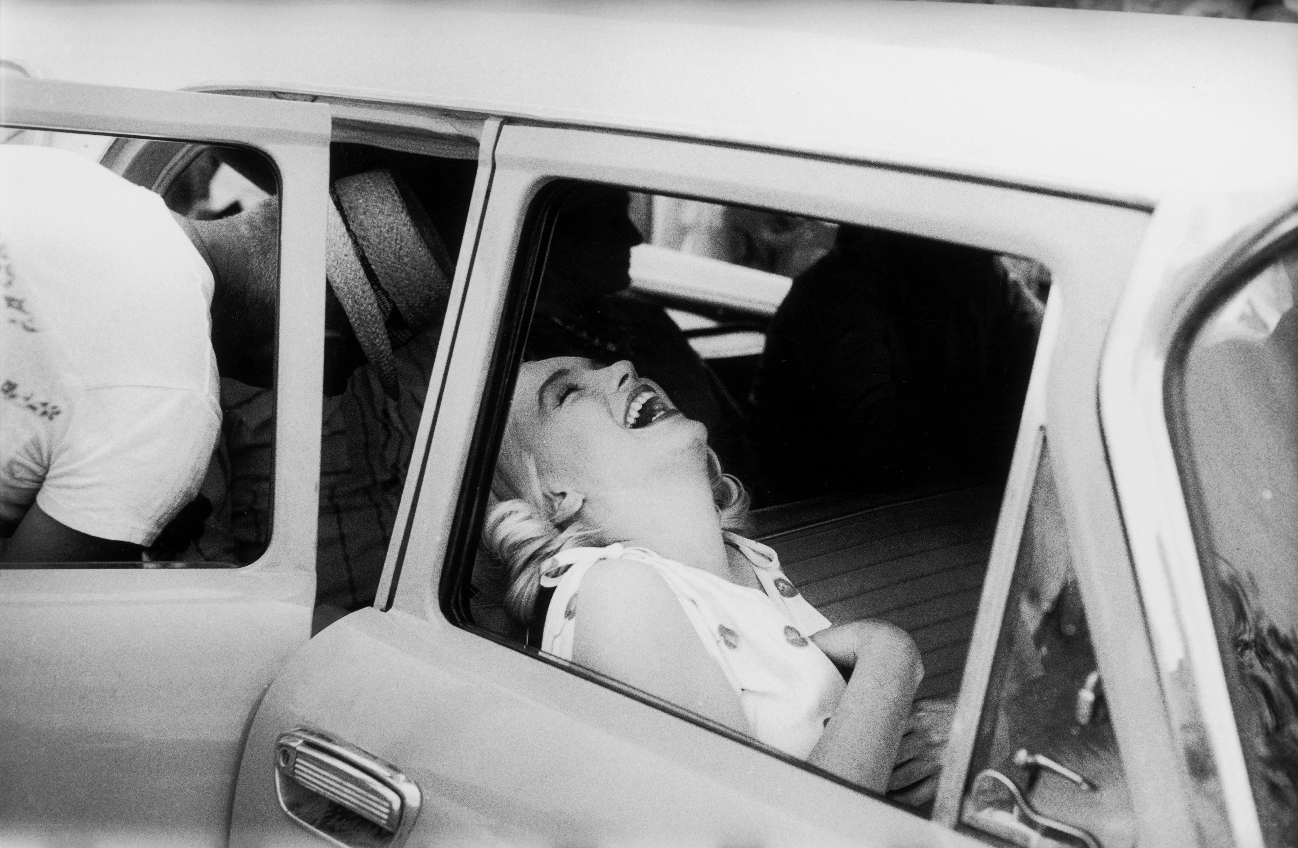 Marilyn Monroe laughing in a car