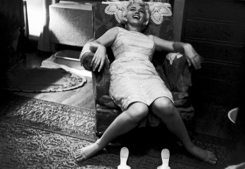 Marilyn Monroe laughing in a chair