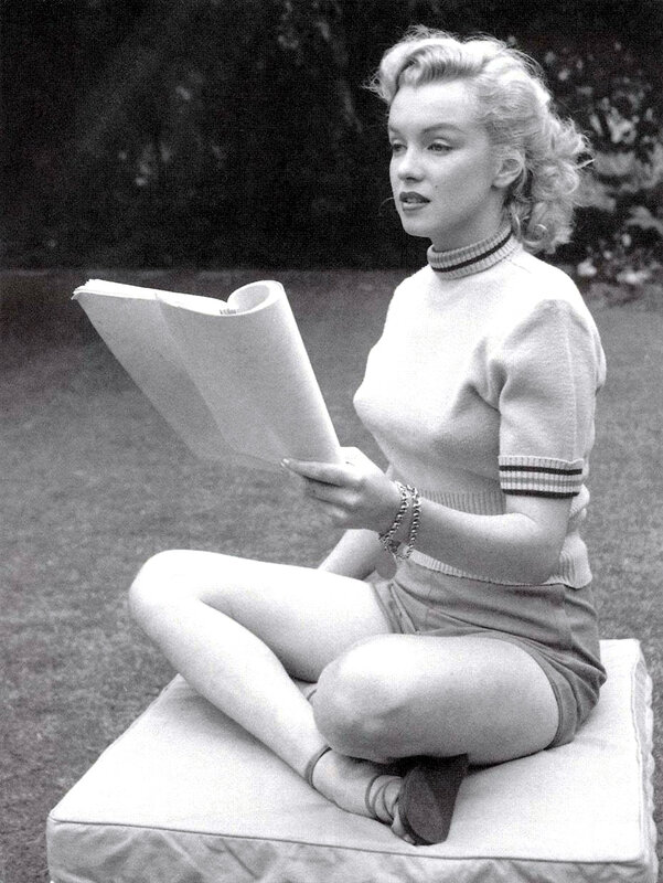 Marilyn Monroe reading outdoors