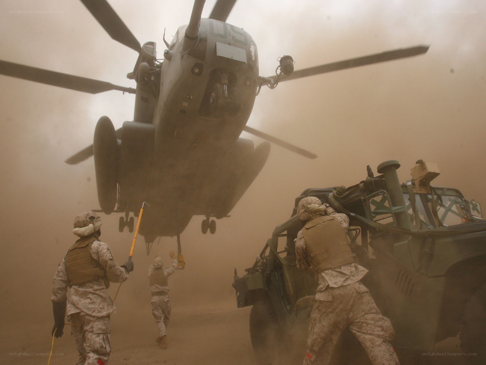 Marines load vehicle under helicopter
