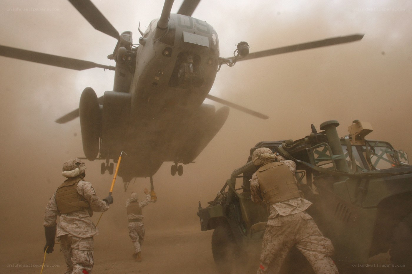 Marines load vehicle under helicopter