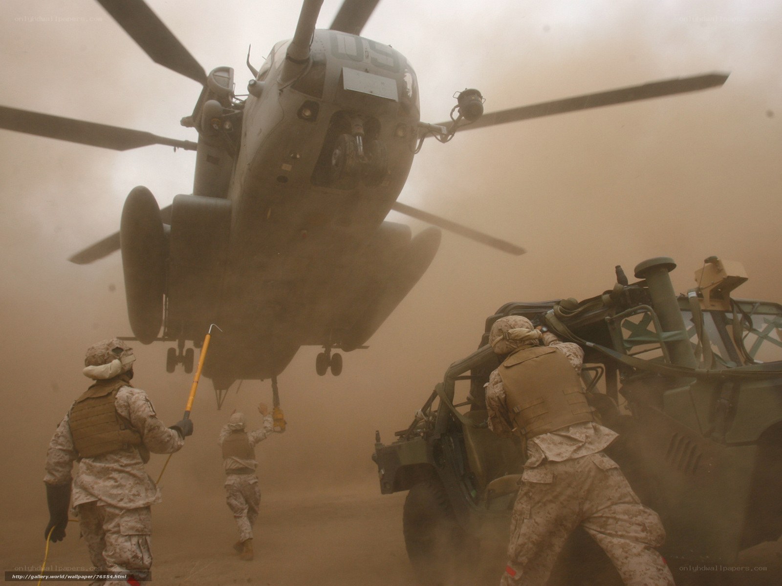 Marines loading cargo under helicopter